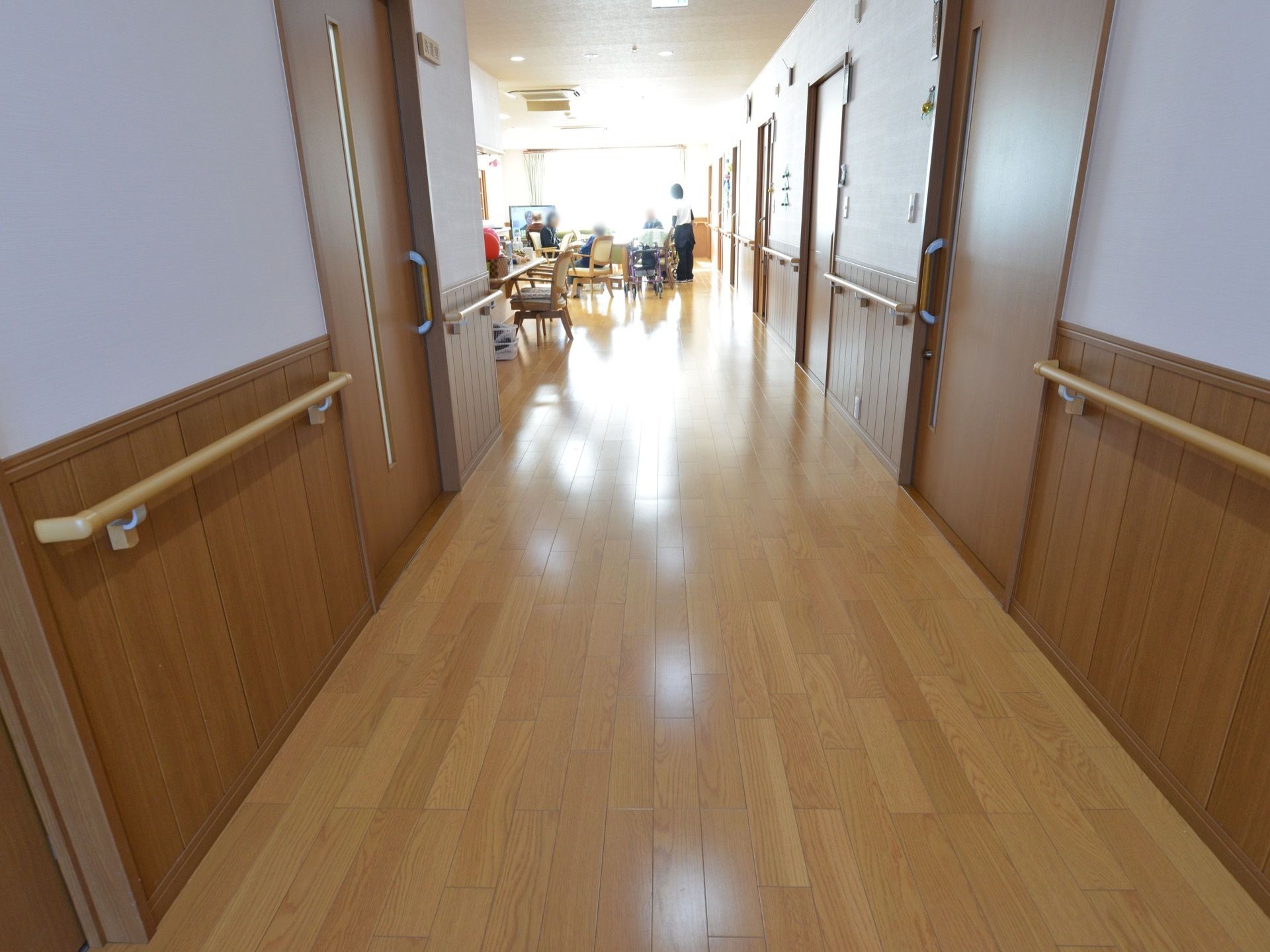 木目調の素材を多く使い、温かみのある内装である。壁には手すりが設置されている。通路は共有スペースと一体化しており開放的である。
