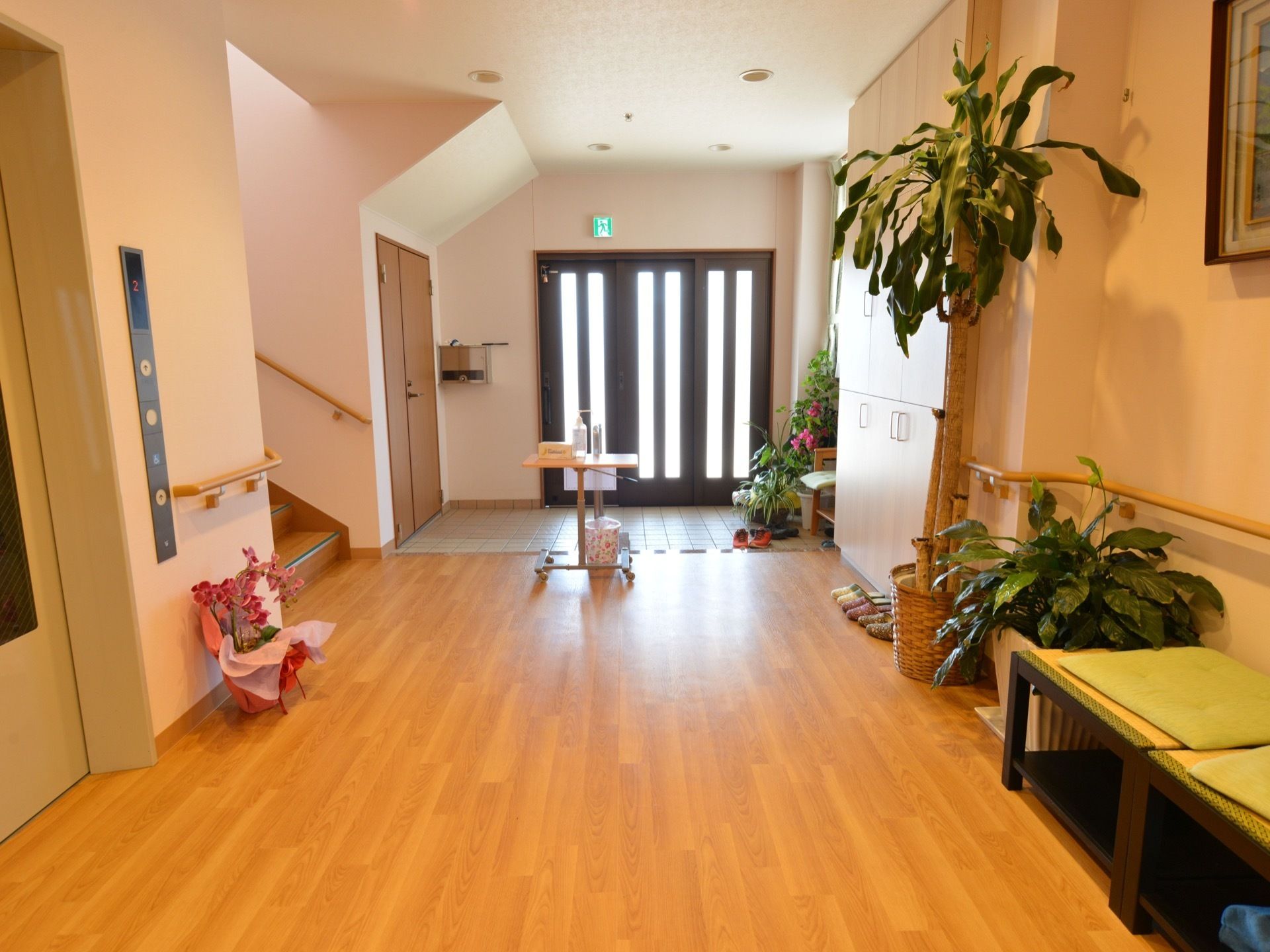 玄関の扉から光が入り明るい。床には段差がなく安全である。階段とエレベーターが近く、施設内の移動がしやすい。