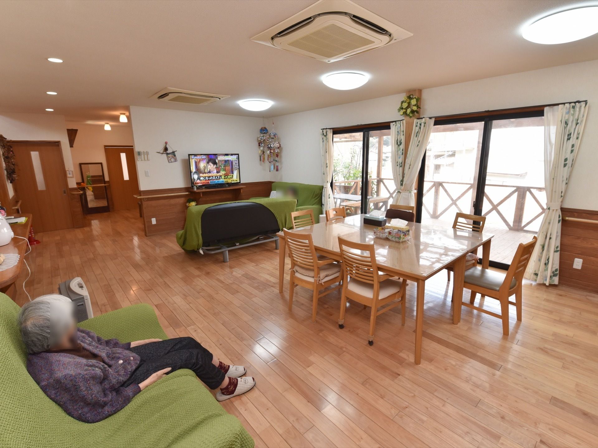 リビングの天井には照明器具があり、埋込み型の空調設備を設置している。また室内には大きな窓が用意されている。