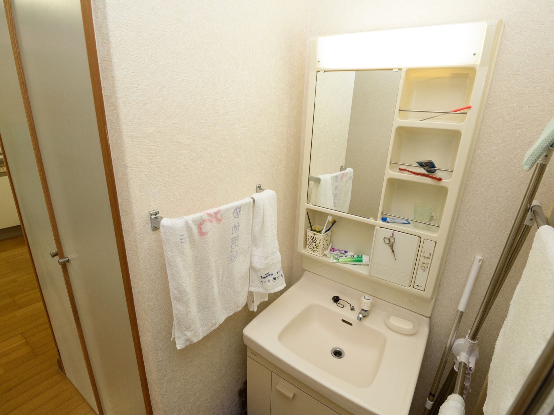 洗面台には、ライトと鏡がついている。またコンセントの差込口と、４か所の棚、そして足元に扉付きの収納がある。