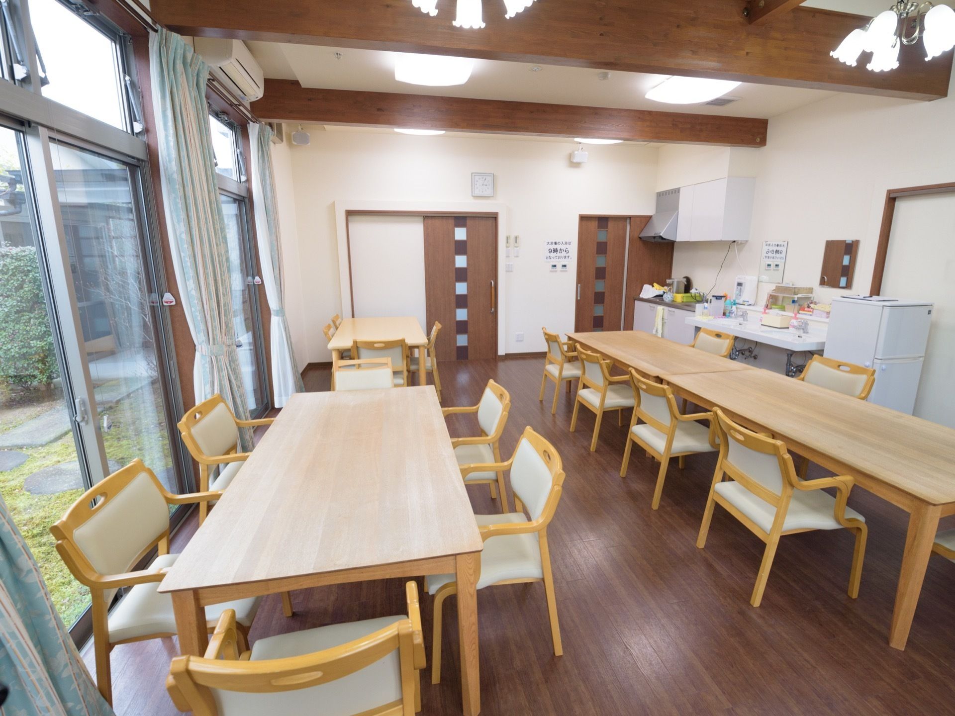 キッチンや洗面台が備わった食堂である。ダイニングテーブルや椅子が用意されている。奥には、大浴場の扉がある。