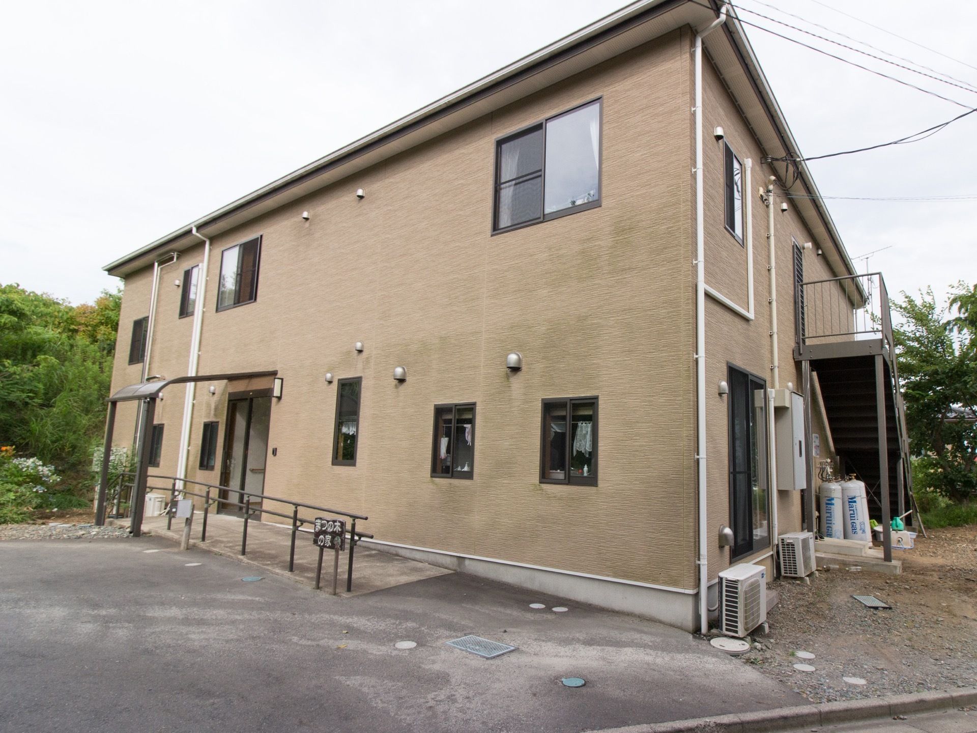 一軒家風の２階建ての建物である。玄関にはスロープがあり、敷地内は段差なく移動できる。周囲は緑に囲まれている。