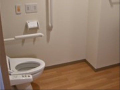 「スマイルホーム豊栄」のトイレ。入居者様の下半身を軽減できるよう、トイレの左右に外壁を施している。