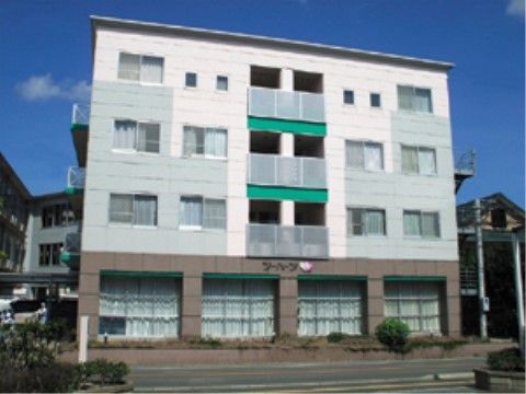 有料老人ホーム ツーハーツⅠの外観。白い外壁に緑がアクセントのおしゃれな施設外観。駐車場を完備している。