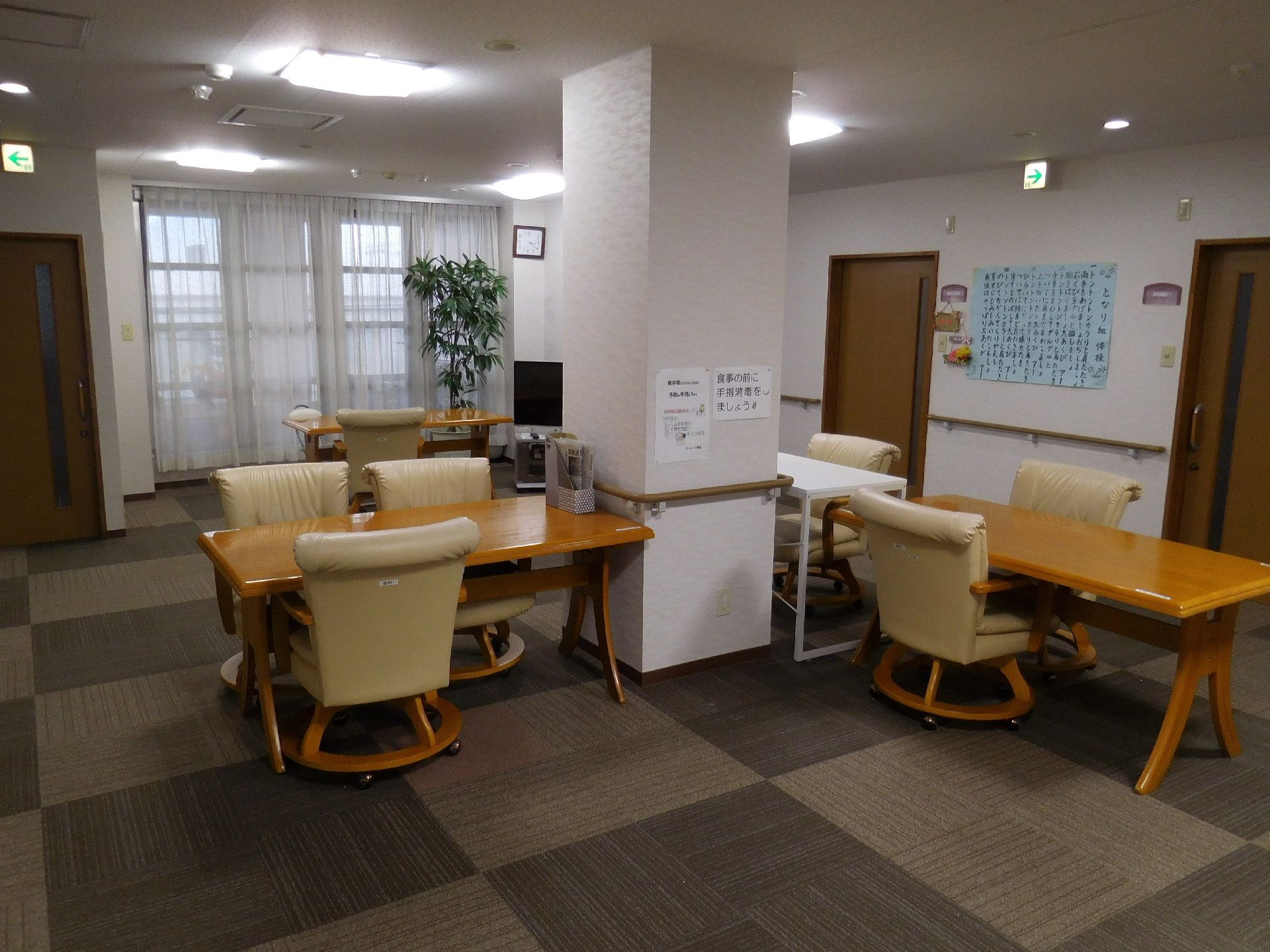 食堂は広いホールの中央と窓際にテーブルと椅子が設置されている。テーブル1つにつき椅子が3つあり壁には注意書きが貼られ奥にはテレビもある。
