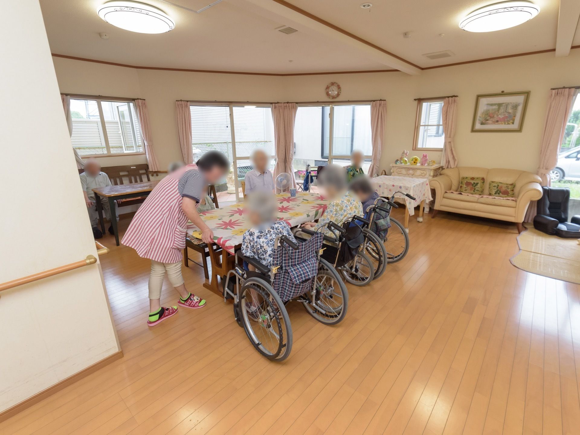 ゆったりとした広さの食堂。花柄のテーブルクロスのかかったテーブルが複数ある。部屋の周囲には、ソファや座椅子などが置かれている。