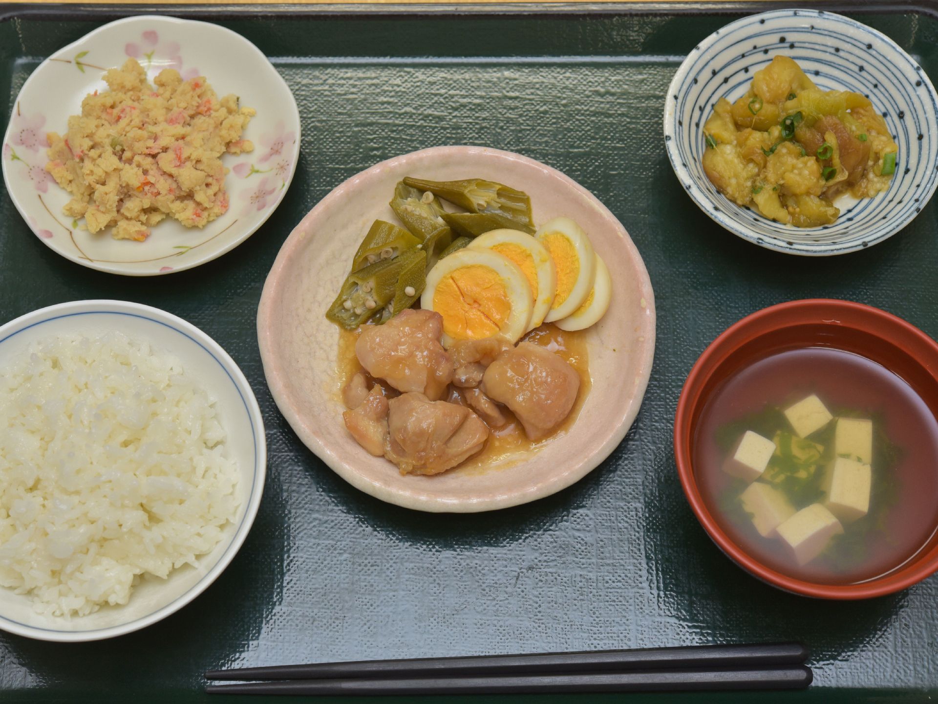 食事のメニューはご飯と豆腐のお吸い物、鶏肉にゆで卵、オクラ、野菜のあえ物など栄養バランスが考えられたメニューになっている。