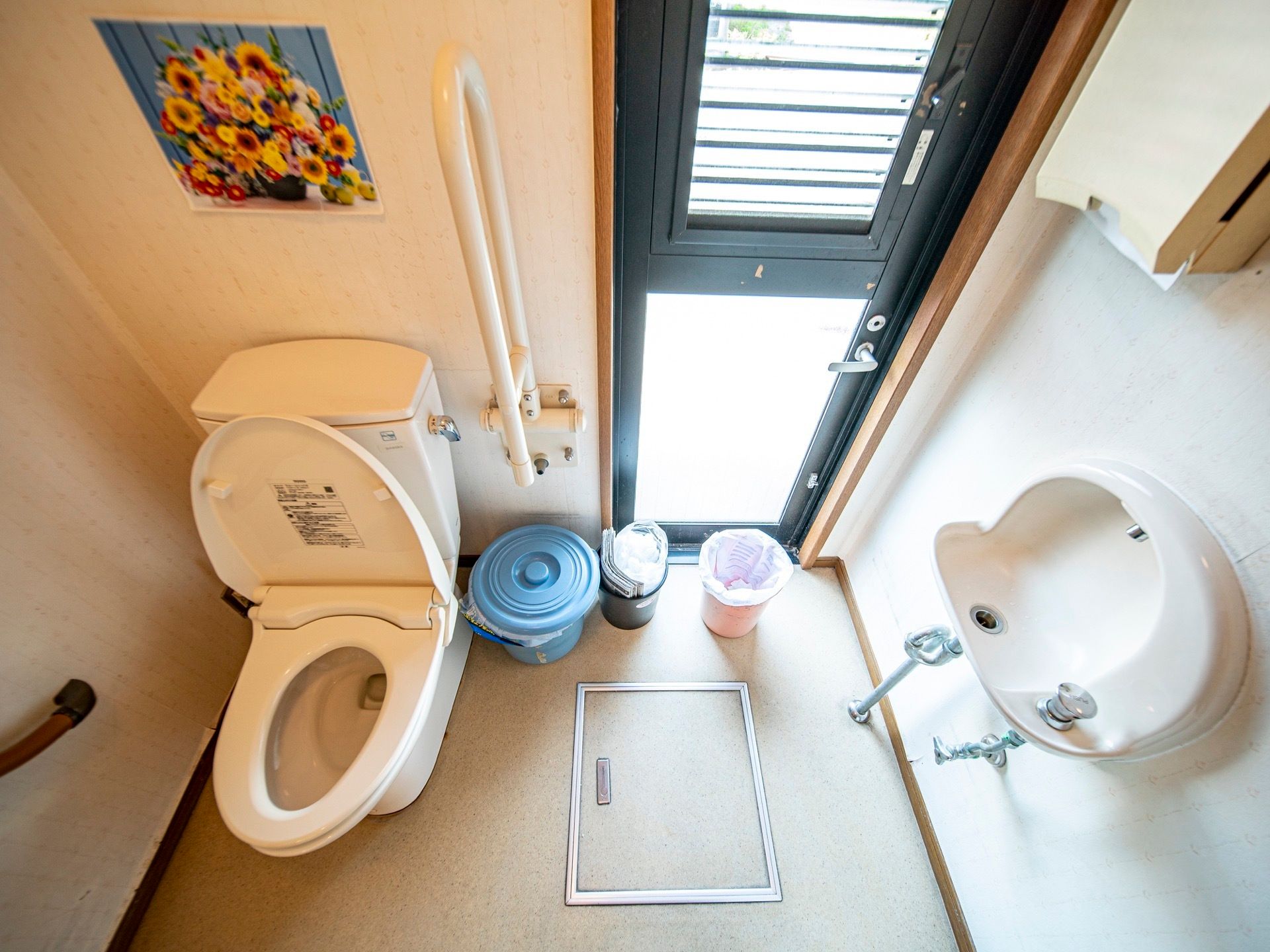 トイレの側には、その場で手を洗えるように洗面台が設置されている。壁には、ひまわりの絵が貼られていて華やかな雰囲気になっている。