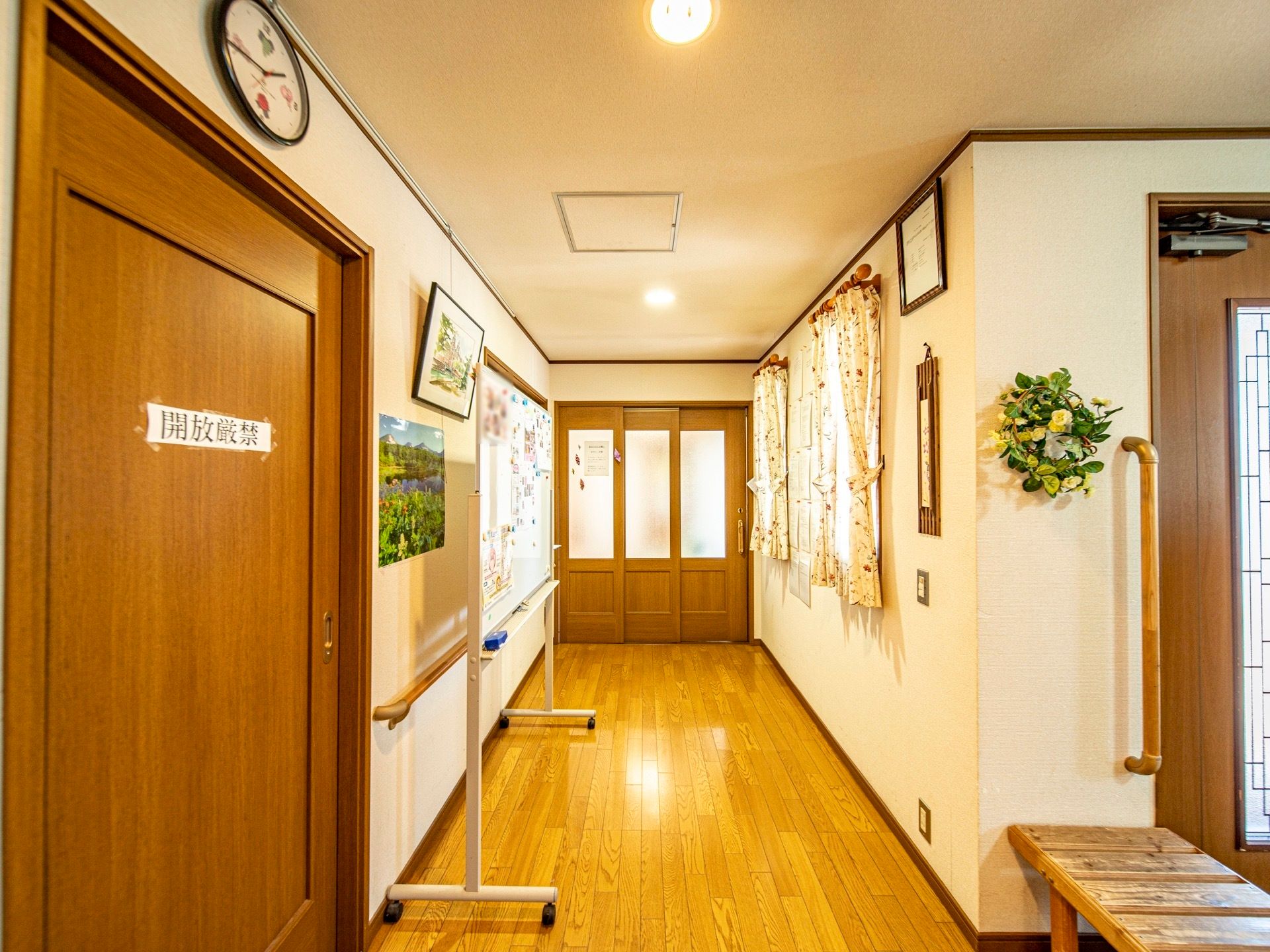 幅が広い廊下になっており、部屋のドアも横スライド式になっている。写真が飾られたホワイトボードが設置されている。