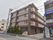 マンション風の４階建ての外観は、シックな色調にまとめられていて落着いた雰囲気である。建物横には駐車スペースが用意されている。