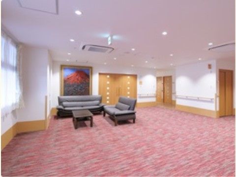 暖色系のカーペットを敷き詰めたフロアの一角にソファセットを設置し、歓談や休憩に利用できるようにしている。