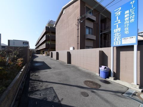 マンションや高齢者向け住宅が並んでいる、車通りの少ない一本道