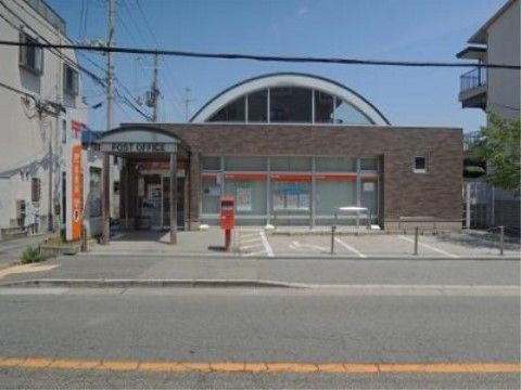 施設の近くに郵便局がある。レンガ調の外壁で駐車スペースが３台分用意されている。郵便局の前に郵便ポストが設置されている。