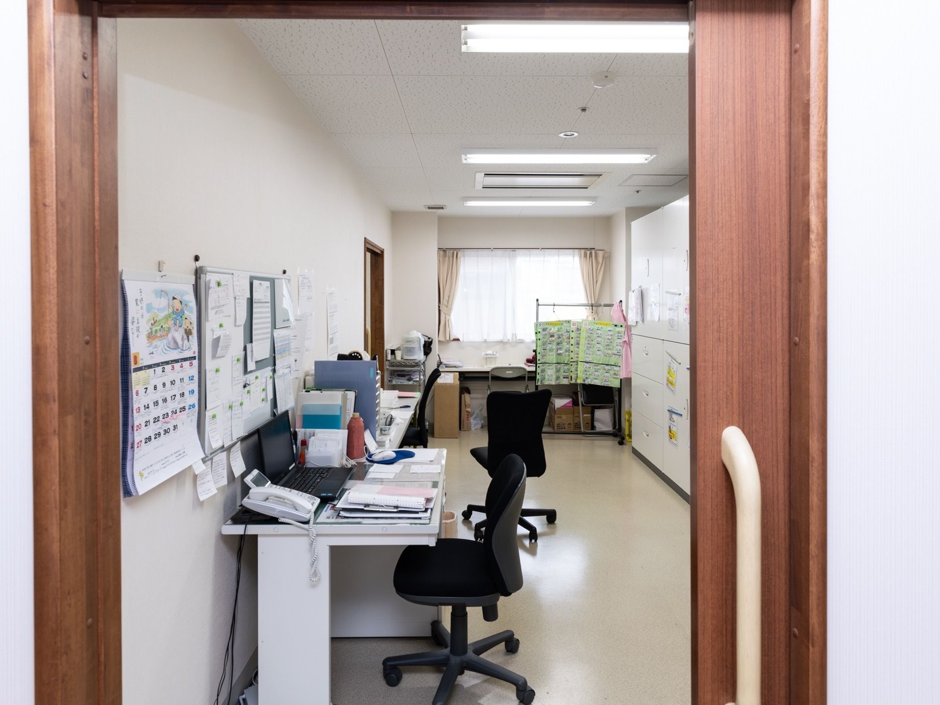 スタッフルームには事務機器が取り揃えられており、入居者様に関する記録などをまとめている。事務椅子の後方には、広めのスペースがある。