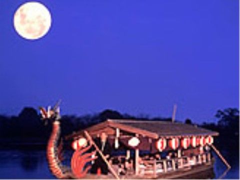 美しい満月の夜の湖畔に浮かぶ、竜をモチーフとした屋形船