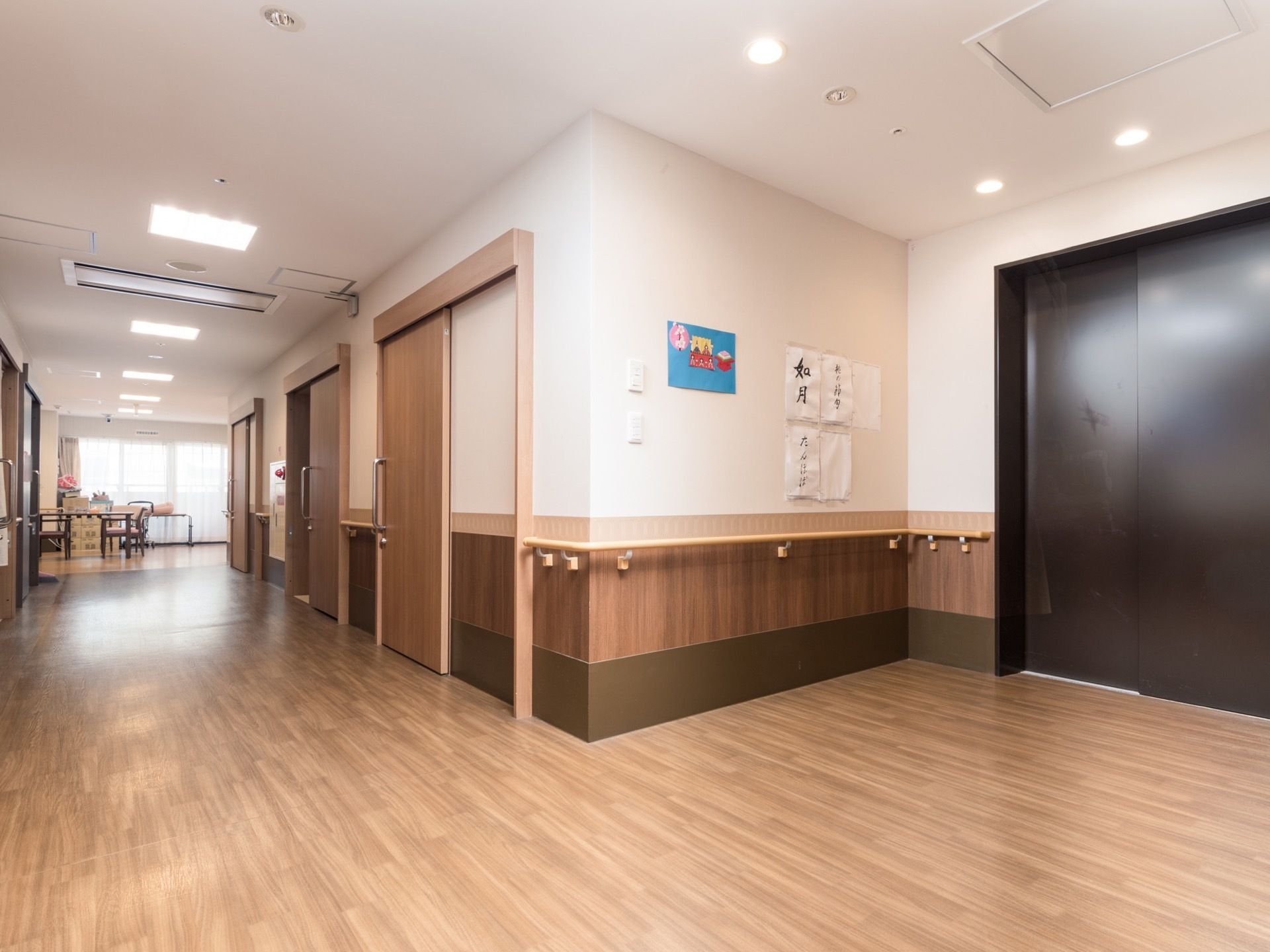 施設内のリビング兼食堂付近の廊下の様子。床は広い面積にわたり、つなぎ目のないフローリングになっている。