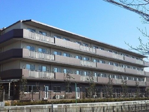ブラウンを基調とした4階建てのマンションのような建物