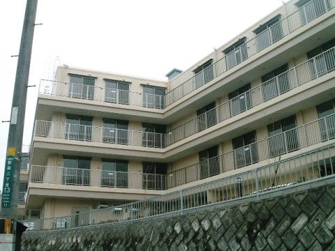 ベージュを基調とした４階建てのベランダが設置されている建物