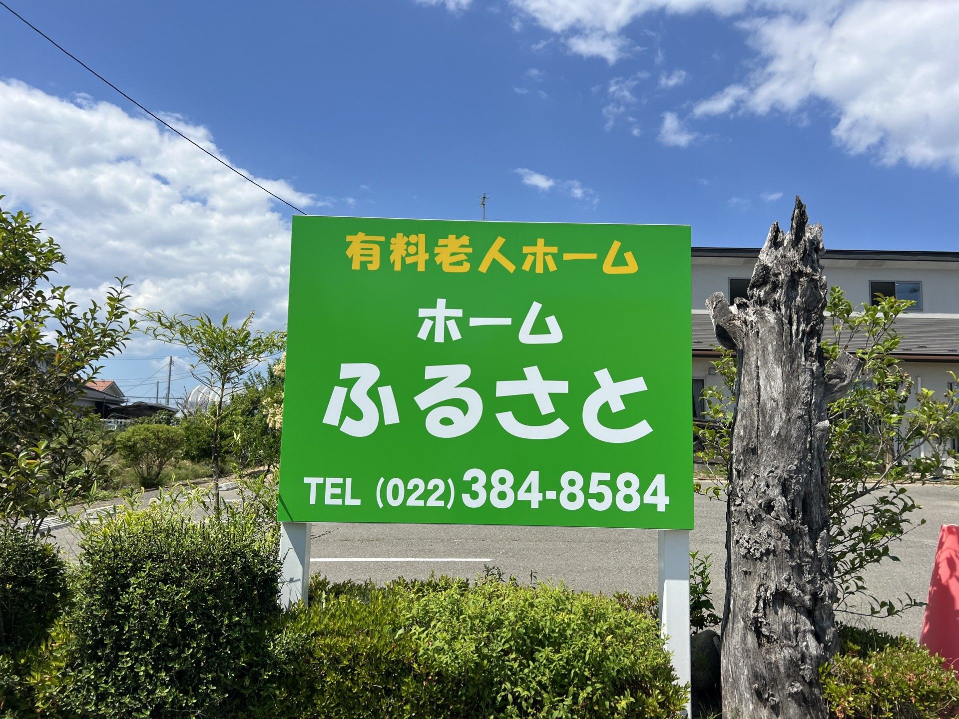施設の周囲には木製の壁や柵があり、温かみのある雰囲気。施設名が書かれたプレートが取り付けられている。