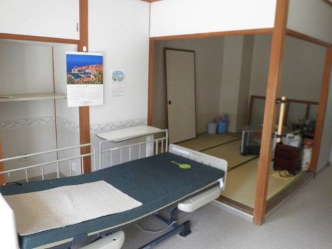 介護用ベッドが置かれた部屋、奥に小上がりで畳のスペース