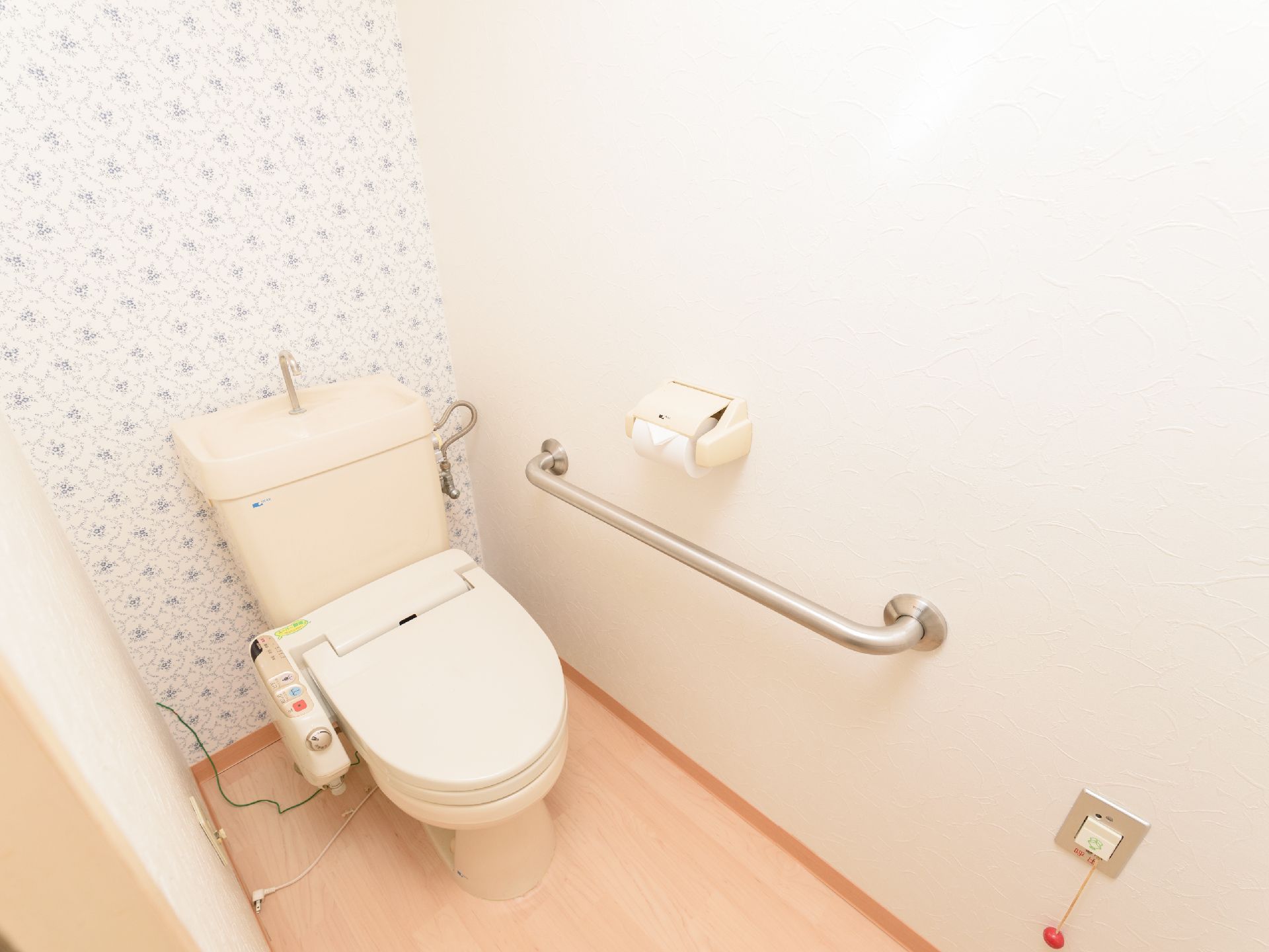 温水洗浄機能付きの洋式トイレである。足元には非常用ベルを設置しているため、安心してトイレを済ませることができる。