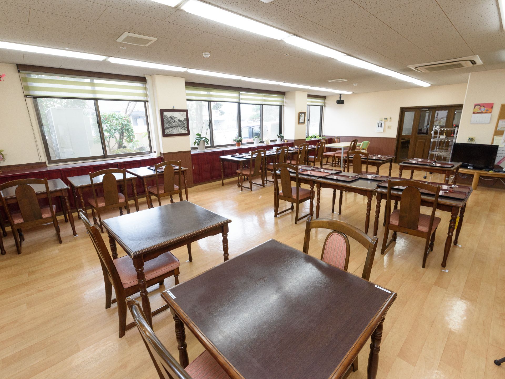窓から陽が入る食堂に、現代風のおしゃれなテーブルや椅子が設置されている。エアコンやテレビなども完備されている。