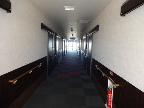 白とこげ茶色のコントラストが美しく、消火器が設置された廊下