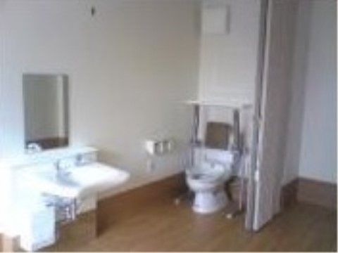 床はバリアフリーで介護用の手すり等が付いた洗面台とトイレ