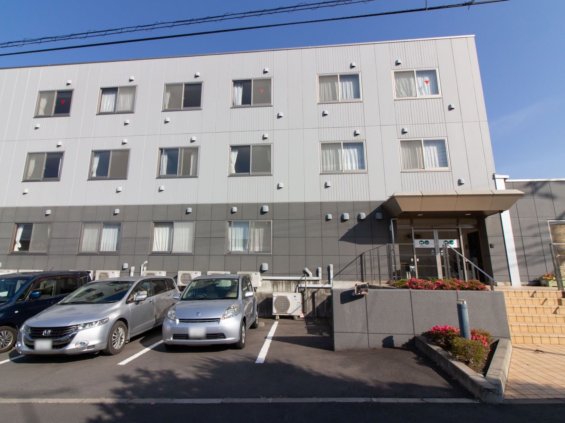 建物の前面に、駐車場が設けられている。駐車場からエントランスへのアプローチは、階段またはスロープである。