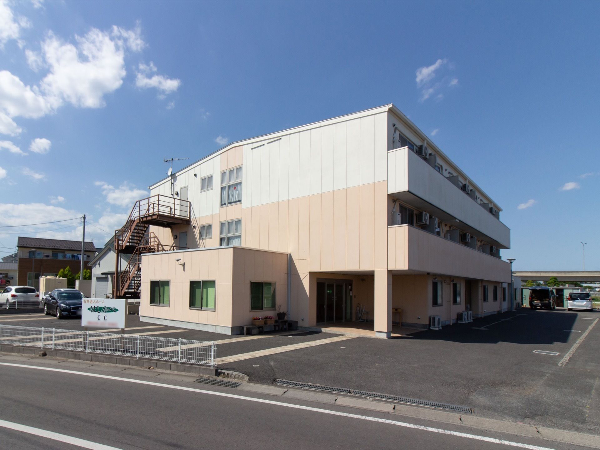 広々として日当たりの良い敷地内には、来訪者様のために多数の駐車スペースがある。エントランスに屋根が設置され、雨風をしのげるようになっている。