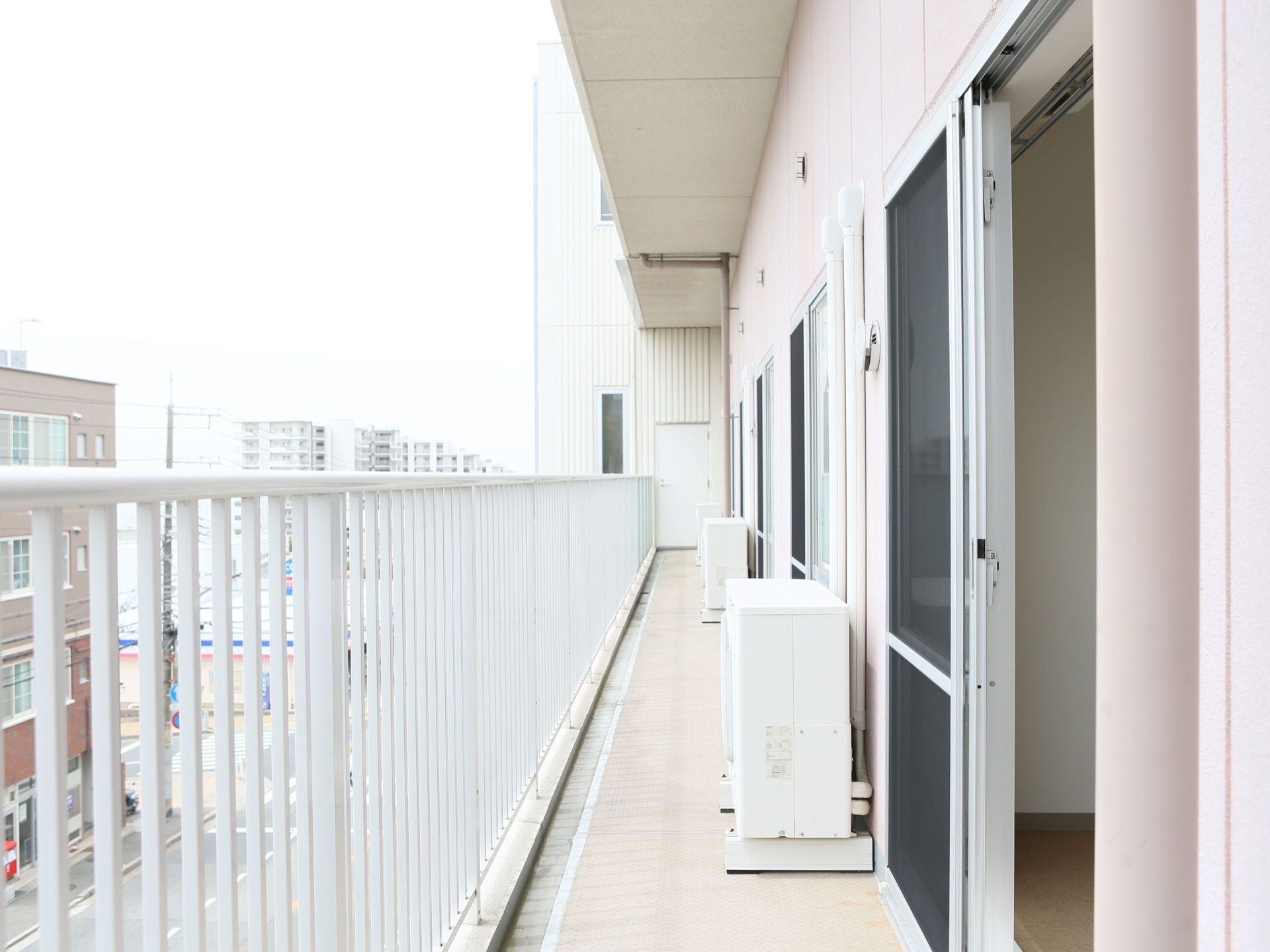 居室にはベランダがあり、居室内に光や風が入る。落下防止の手すりが設置されている。エアコンの室外機が置かれている。