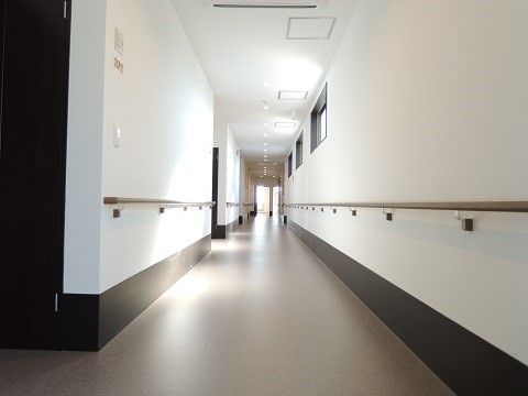 「ふじがおか おおるり メゾンド安久路」の廊下。壁には左右に介助手すりを設置し、移動のスムーズさを与えている。