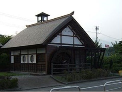 宿場町の面影を残している宿跡の風景である。大きな屋根の建物の壁面には水車があり、周囲は豊かな緑に囲まれている。