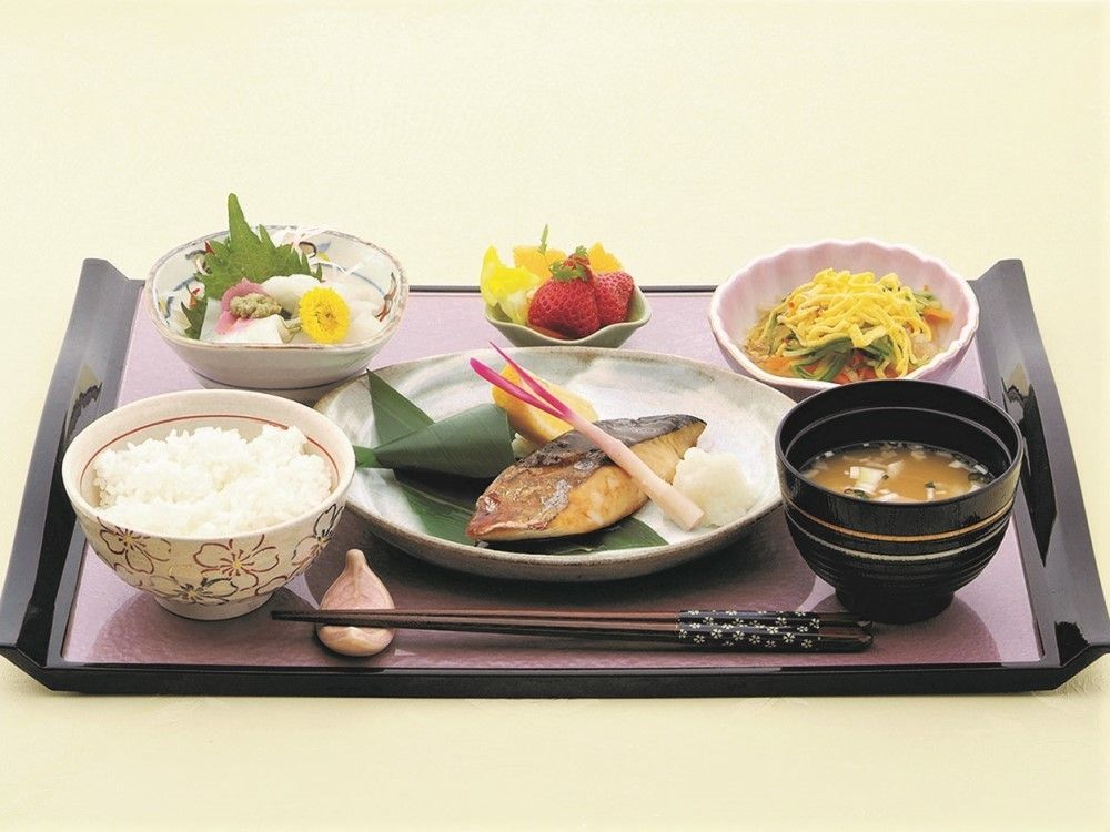 懐石料理のように盛り付けられた焼き魚が主菜の、色鮮やかな食事