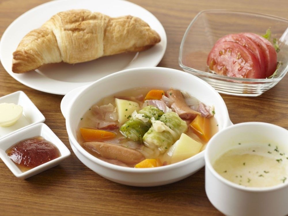 ポトフにクロワッサン、トマトサラダなどが付いた洋風の食事