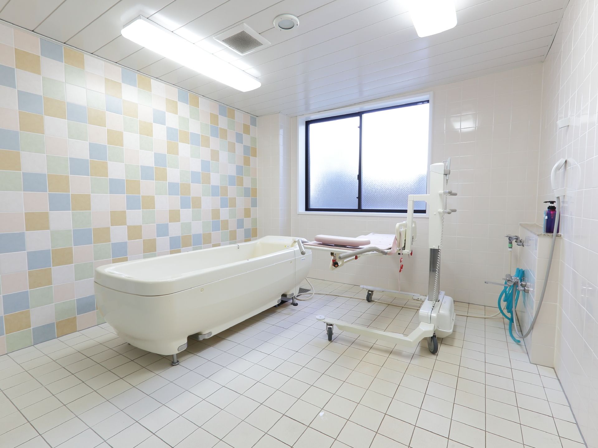 広い浴室である。一面の壁はカラフルなモザイクで、他の壁や床は白色のタイル張りである。特殊な入浴装置が置かれている。