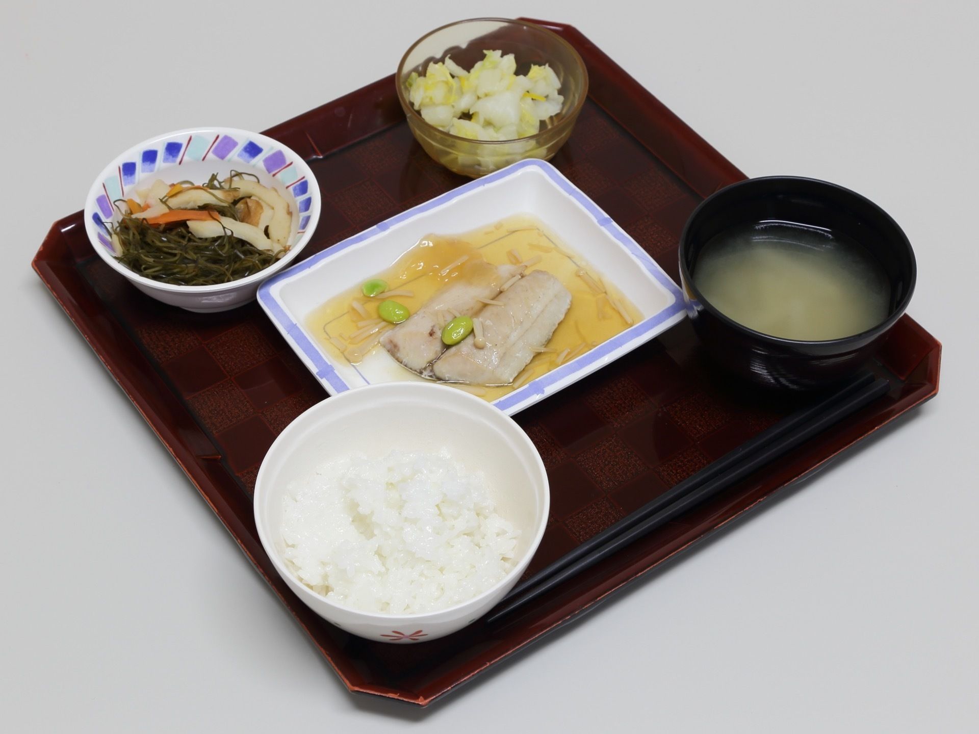 四角い朱塗りのお盆の上に、ご飯、味噌汁、主菜、副菜二皿が載っている。この日の主菜は魚のあんかけである。