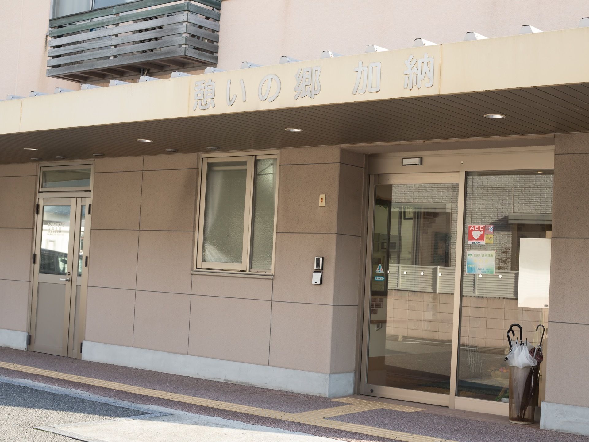 扉は自動扉になっており、壁にはインターホンが用意されている。外には傘立てが置かれている。通路には点字ブロックが設置されている。