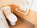 居室内のトイレである。Ｌ字型の手すりや緊急時呼出ボタンが備わっている。トイレの扉は蛇腹式のカーテンが使われている。