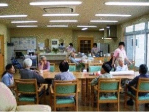 揃いのテーブルセットが並び、入居者たちが集まっているダイニング