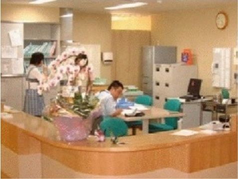 木製でカーブを描いた形状になっている、鉢植えが飾られた受付カウンター