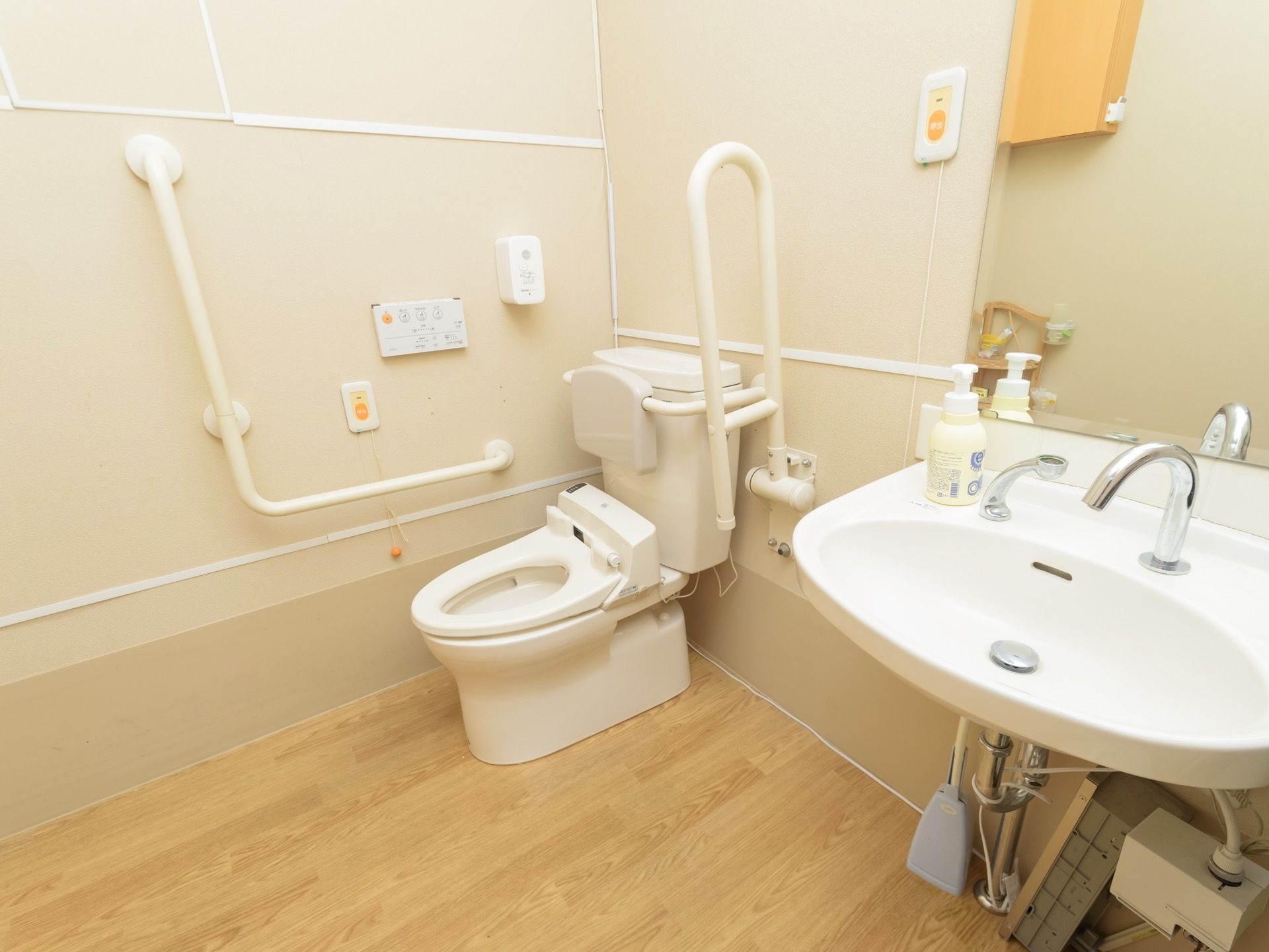 トイレは明るく開放的で、広々とした造りになっている。温水洗浄便座と一緒に洗面台が個室内に併設されている。