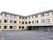 施設は3階建ての建物である。外壁はベージュ系で黒いフレームの窓が並んでいる。前面に広い駐車場が設けられている。