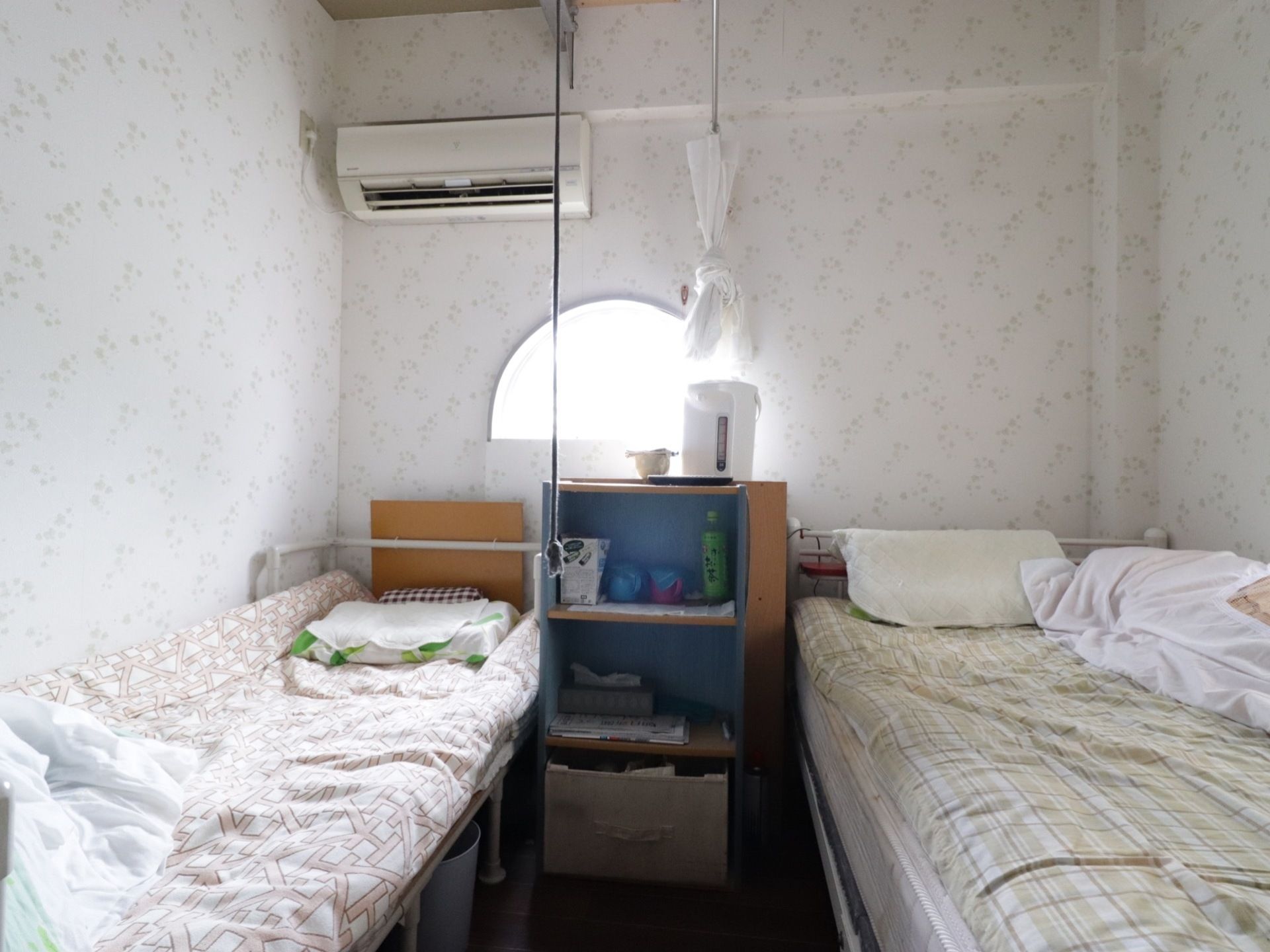 白い壁で施工された、シンプルな部屋である。丸型のおしゃれな窓からは、明るい日差しが届いている。エアコンも完備。