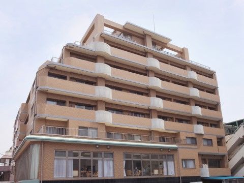 マンションのような造りで、黄土色の外壁を持つ七階建ての施設外観
