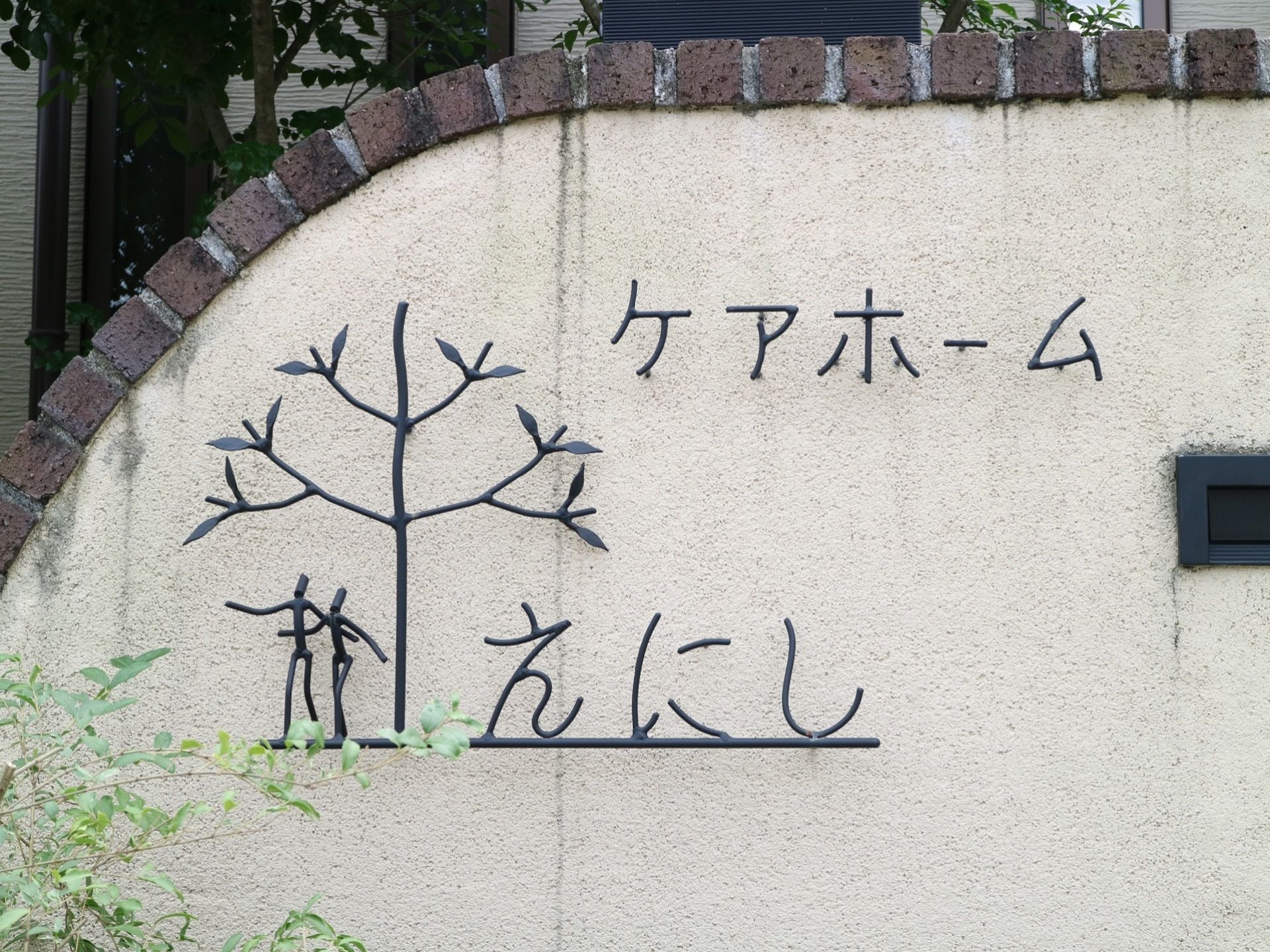 アイボリー色の壁にレンガ風のブロックで縁取りがなされている。黒い金属でホーム名やホームのマークが形作られている。