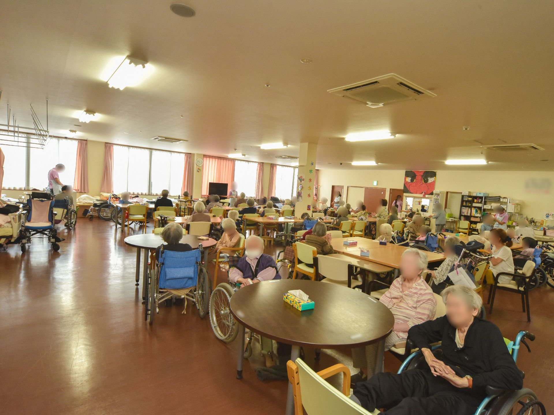 明るくアットホーム的なリビングである。天井にはエアコンが設置され、横一面に窓があり、外の風景を一望できる。テーブルと椅子が置かれている。