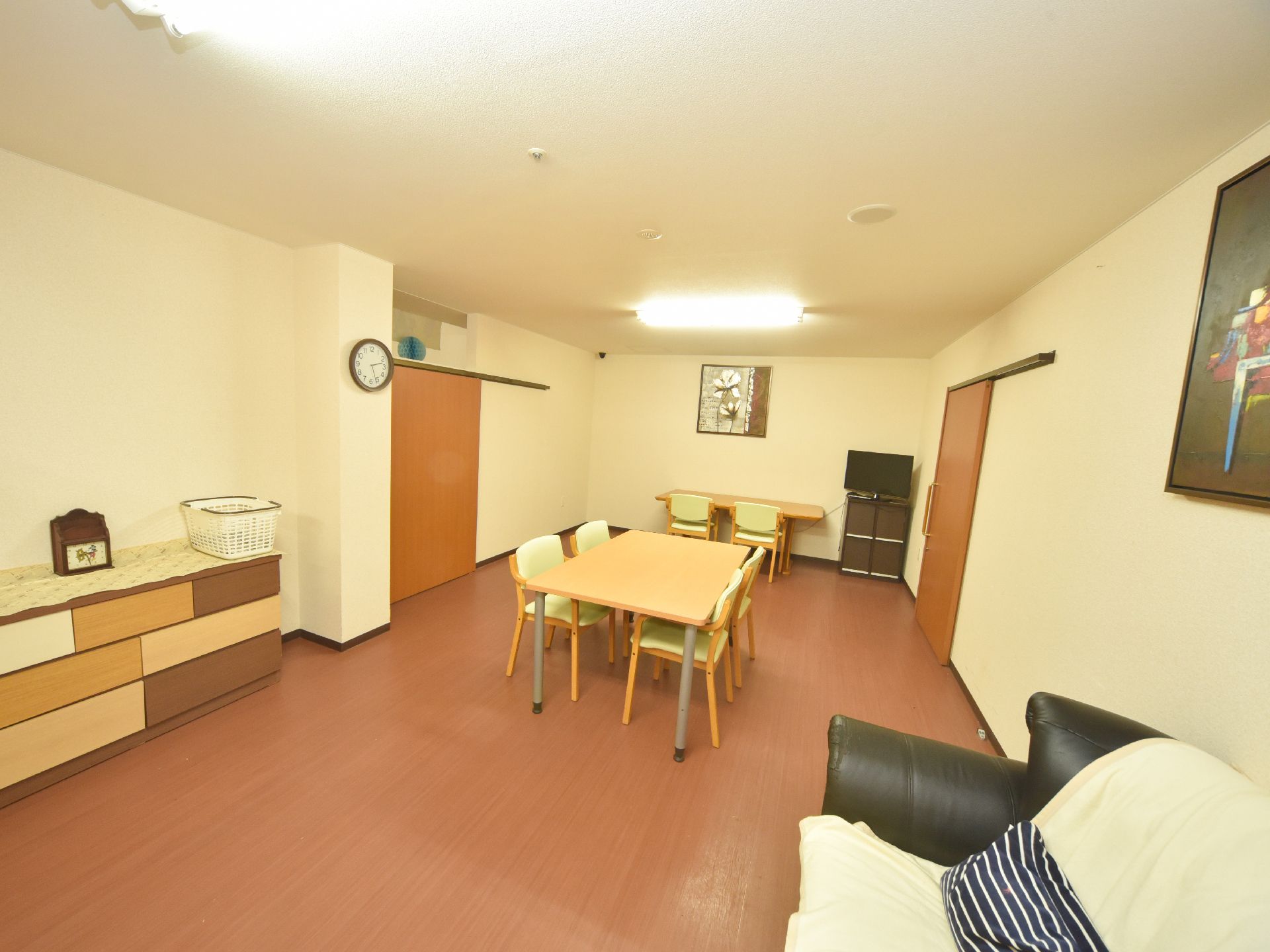 ソファ一台、テーブルが二台、椅子が六脚、テレビが一台置いてある。部屋の戸は、スライドで開閉する。絵画が壁にかけてある。