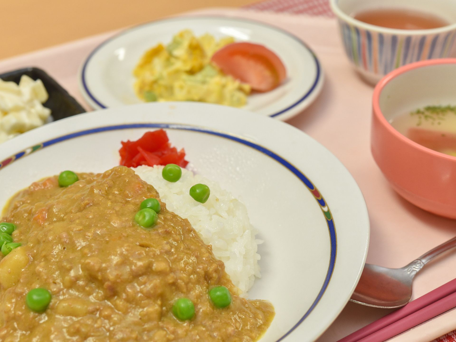 グリーンピースと福神漬けがトッピングされているカレーライスである。お肉はひき肉が使用されている。彩りが鮮やかである。