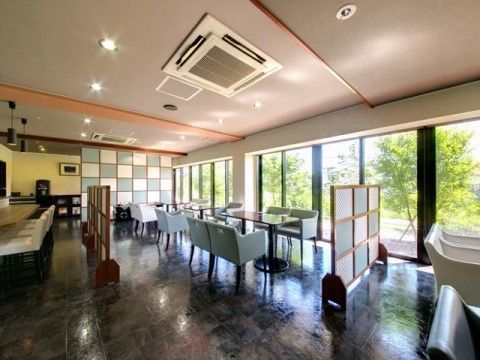 黒い大理石のようなフローリングの上に、テーブルセットが並んでいるリビング